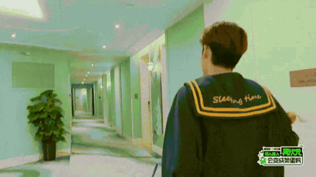 a person wearing a jacket that says sleeping time is walking down a hallway