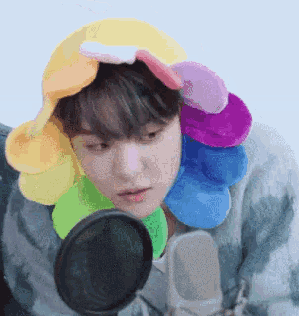 a person wearing a flower hat is looking at themselves in a mirror .