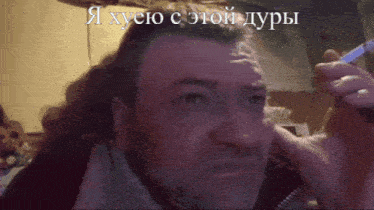 a man with a beard is smoking a cigarette with a caption in a foreign language