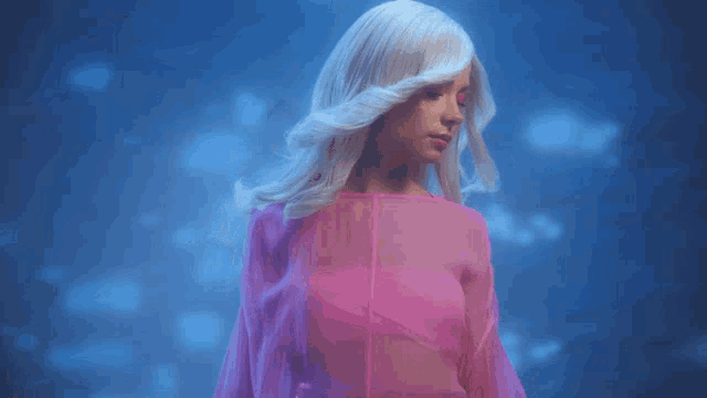 a woman with blonde hair and a pink top