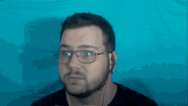 a man wearing glasses and headphones is looking at the camera