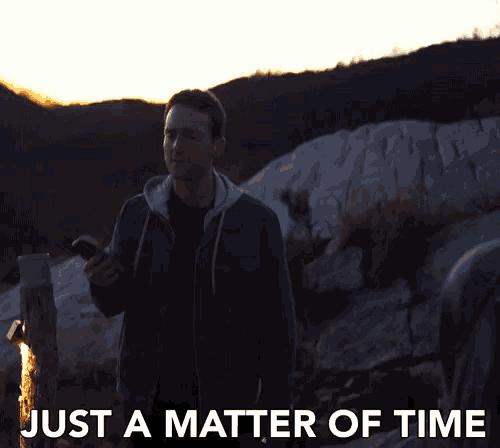 a man holding a cell phone with the words just a matter of time written below him