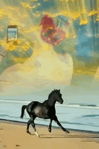 a black horse is running on a beach with a woman behind it