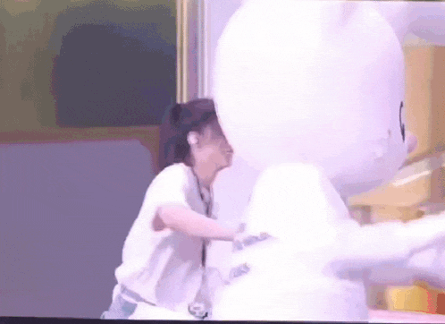 a woman is holding a white balloon in front of a painting .