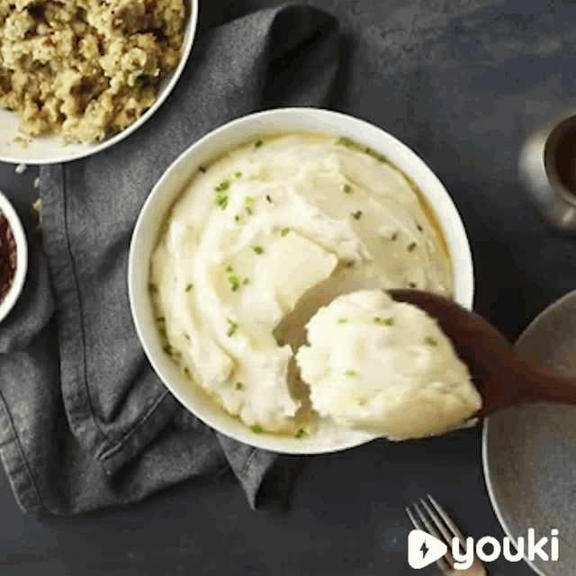a bowl of mashed potatoes is being scooped out of it