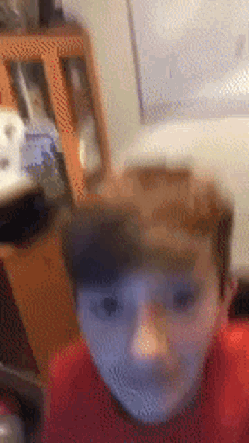 a blurry picture of a young boy 's face in a room .