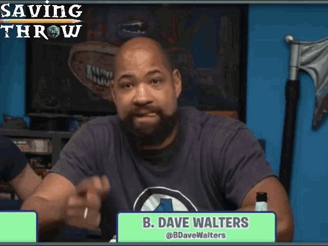 a man with a beard is sitting at a table with a green sign that says b. dave walters