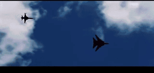 two fighter jets flying in a blue sky