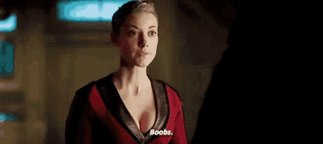 a woman in a red shirt is talking about her breasts .