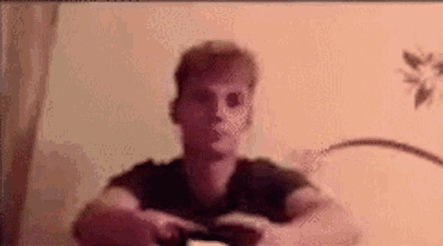 a man in a black shirt is playing a video game with a controller .