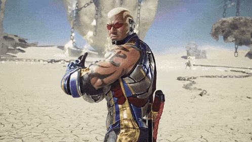 a man with a tattoo on his arm is standing in the desert with chains behind him