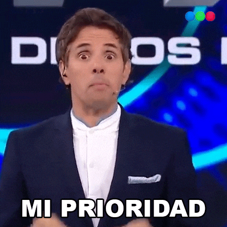 a man in a suit is making a funny face and says mi prioridad