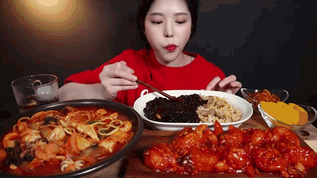 a woman is sitting at a table eating a variety of food