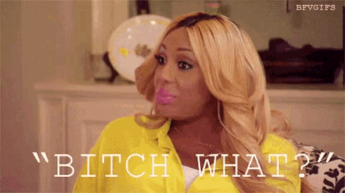 a woman is sitting on a couch with a lollipop in her mouth and says `` bitch what '' .