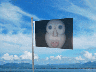 a flag with a picture of a face on it against a blue sky