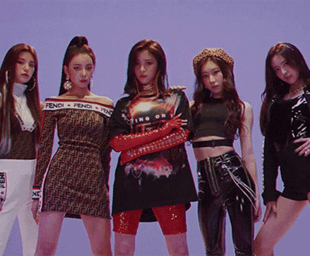 a group of women are posing for a picture and one of them is wearing a fendi shirt