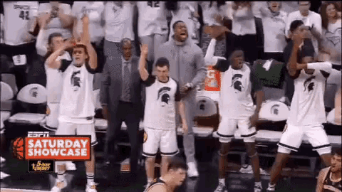 a group of basketball players are dancing in front of a crowd during a saturday showcase .