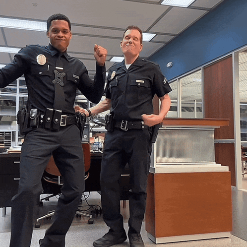 two police officers are posing for a picture and one of them has the number 1 on his uniform