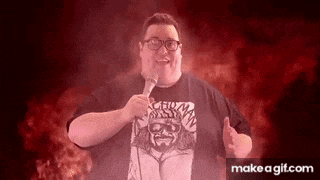 a fat man with glasses is holding a microphone in front of a red background .