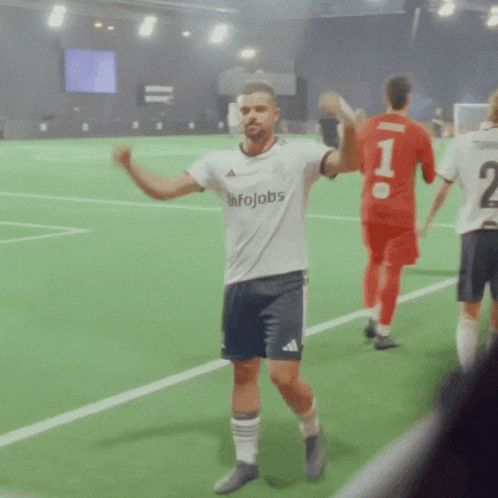 a man wearing a white shirt that says infojobs stands on a soccer field