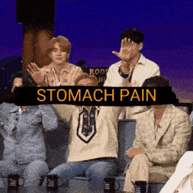 a group of people sitting on a couch with a sign that says stomach pain