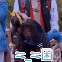 a man is holding a child in his arms in a blurry photo with chinese writing on it .