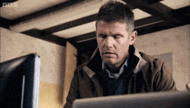 a man sitting in front of a computer with the bbc logo on the bottom right