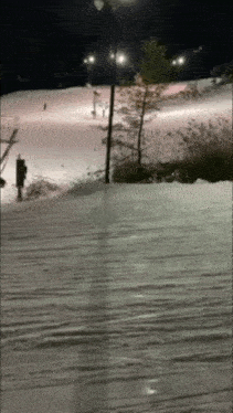 a person skiing down a snow covered slope in the dark