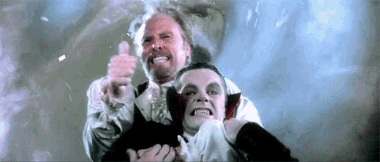a man and a vampire are giving a thumbs up .