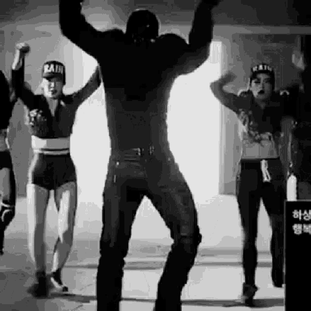 a black and white photo of a group of people dancing in a room .