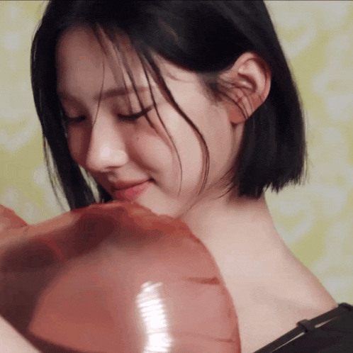 a close up of a woman holding a balloon
