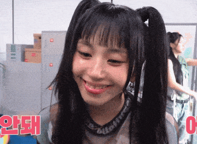 a girl with pigtails is smiling and wearing a necklace that says supreme on it