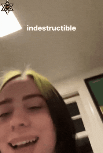 a woman with green hair is smiling with the word indestructible written on the bottom