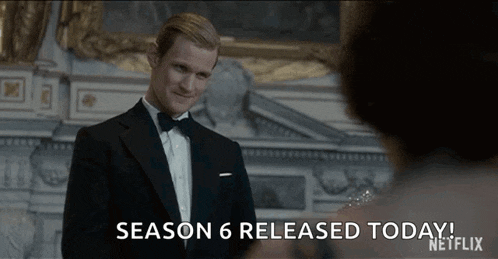 a man in a tuxedo and bow tie is talking to a woman in a ballroom .