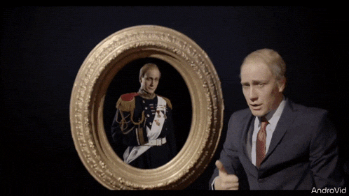 a man in a suit and tie is giving a thumbs up in front of a picture frame