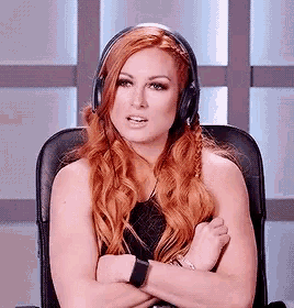 a woman with red hair is wearing headphones and sitting in a chair