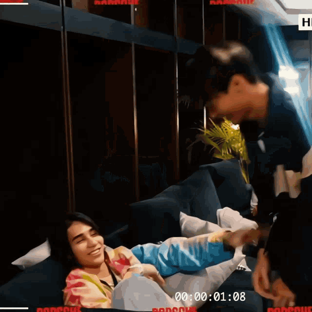 a man and a woman are laying on a couch and the time of the video is 00:00:01