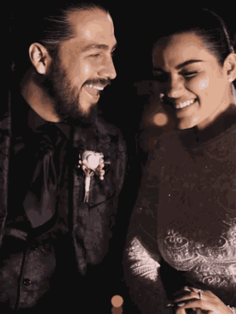 a bride and groom are smiling and holding hands