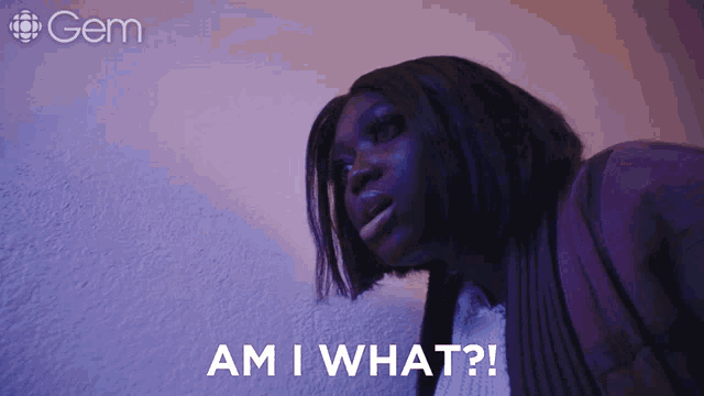 a woman says am i what in front of a purple wall