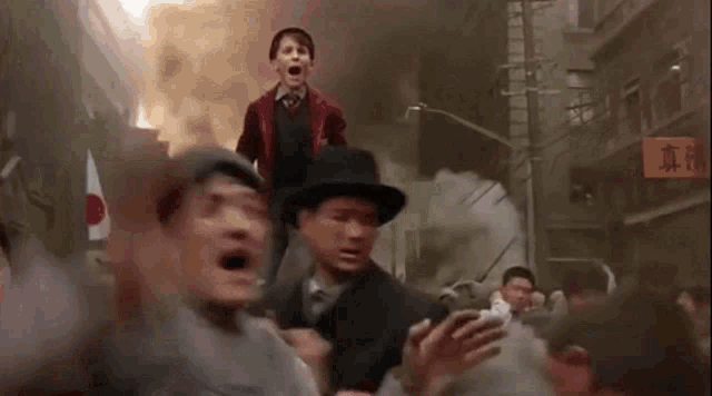 a man in a red jacket is riding on the shoulders of another man in a hat .