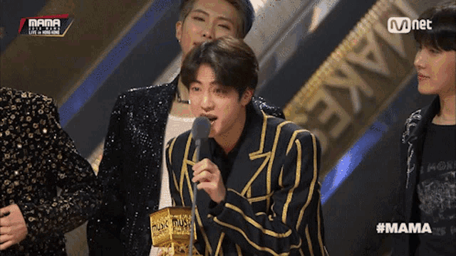 a man speaking into a microphone at a mama award show