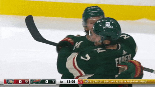 a hockey player with the number 9 on his helmet is hugging another hockey player