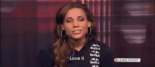 a woman is wearing a red bull shirt and says love it