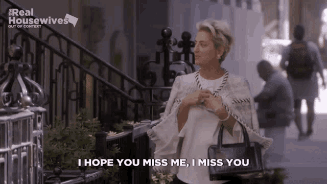 a woman says i hope you miss me i miss you while holding a purse