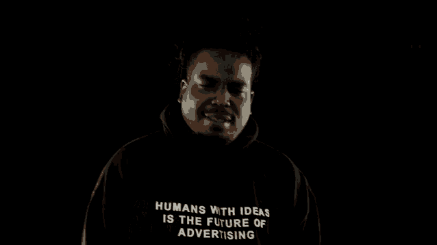 a man wearing a black hoodie that says humans with is the futur advertisement