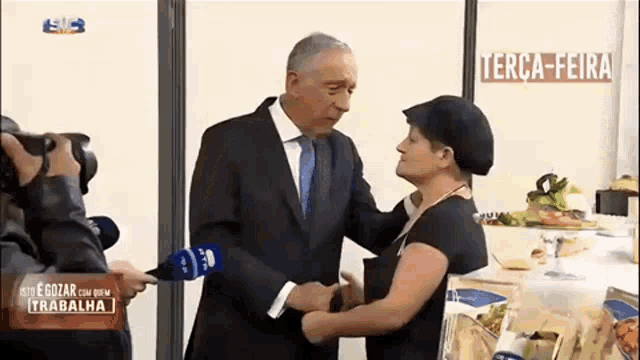 a man in a suit and tie is shaking hands with a woman in a black hat .