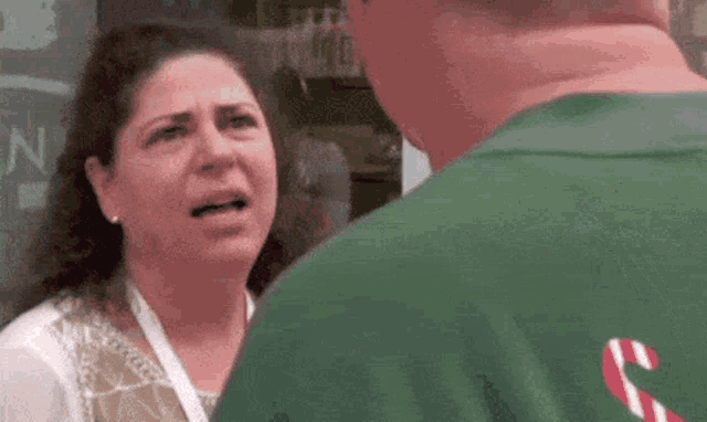 a woman is making a funny face while talking to a man .
