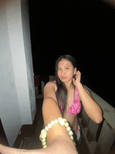a woman wearing a pink bikini and a yellow bracelet