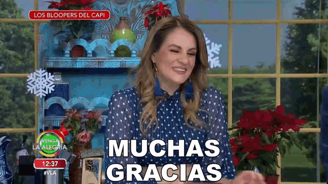 a woman in a blue polka dot dress says muchas gracias in spanish