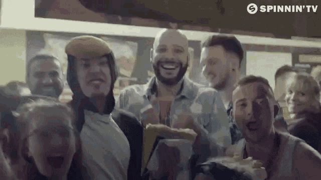 a group of people are standing next to each other in a restaurant and laughing .